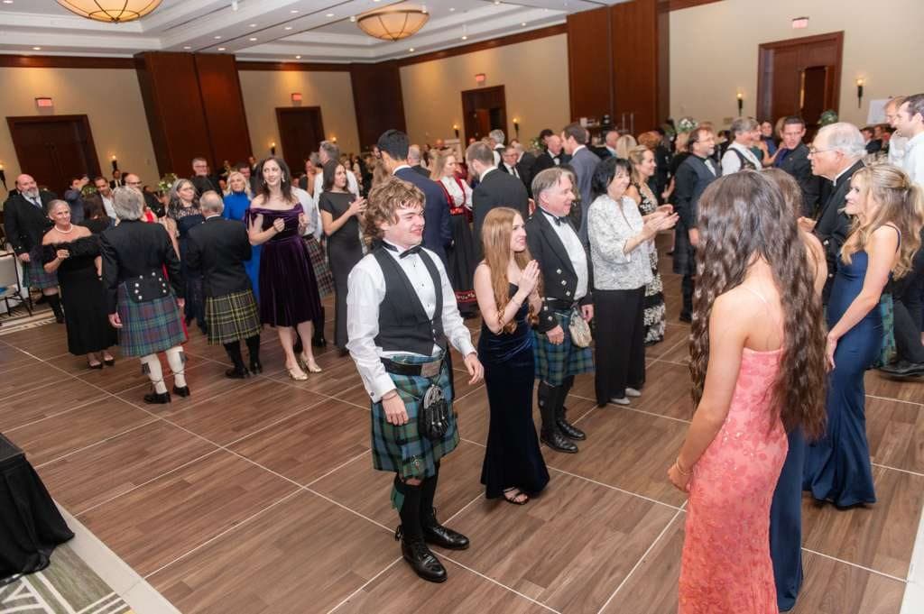 Guests in kilts and black tie filling the ballroom floor at the Westside Burns Supper
